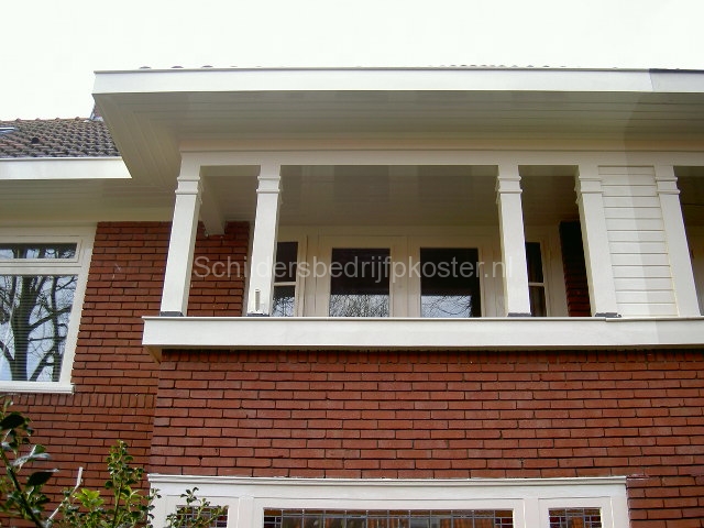 Balkon met witte balustrade en houten delen